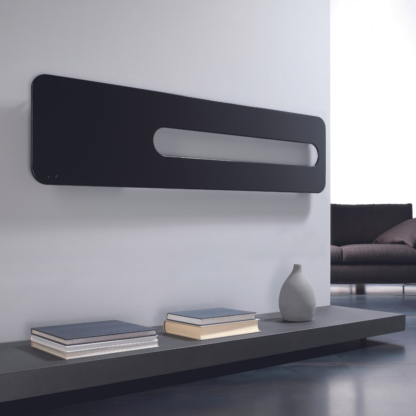 Modern living room with a black wall-mounted radiator and a gray sofa.