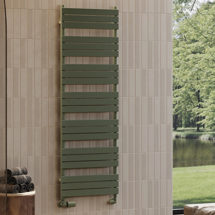 Green towel radiator mounted on a tiled wall with a view of trees and water outside.