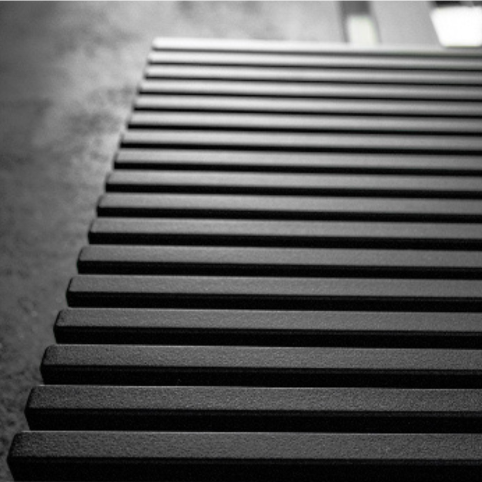 Black radiator against a gray wall